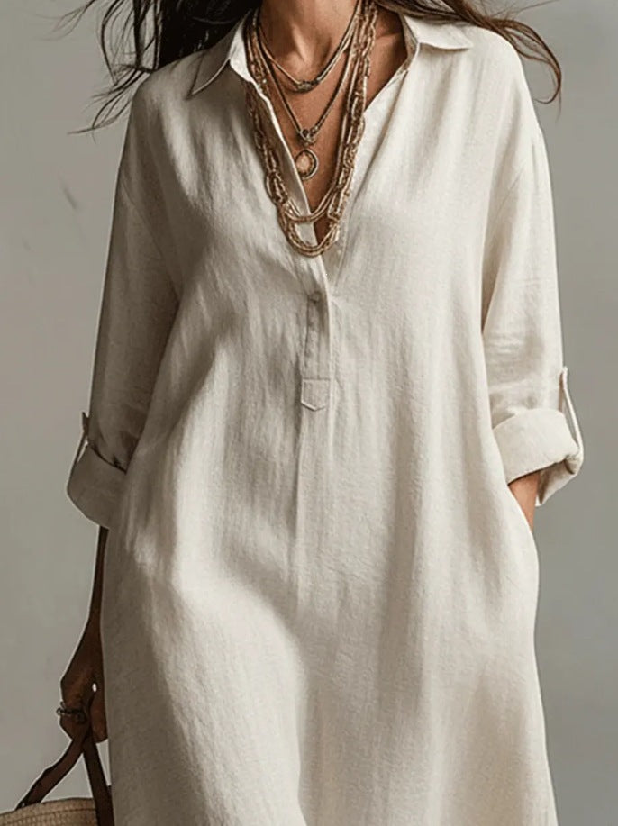 A Beige Linen Shirt Dress With A Relaxed French Vacation Vibe, Featuring A Turned-down Collar With A Half-placket, Rolled-up Sleeves, Side-slit Pockets, And A Long Shirt Dress Designperfect For Trave